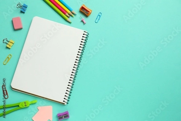 Obraz Assorted educational supplies including pen, notebooks, and stationery placed on a color surface
