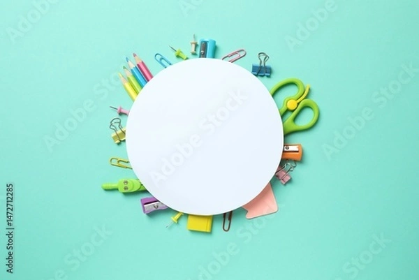 Obraz A collection of school supplies arranged around a white card on a coloured background, ideal for school holidays or an educational context