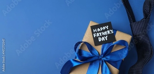 Obraz Happy Father's Day flat lay concept. Top view photo of giftbox with silk ribbon bowand elegant tie on blue background