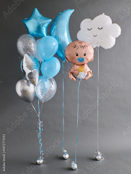Obraz Helium balloon set with stars, moon, smiling cloud, and baby figure in blue, silver, and white. Tied with ribbons and weights, against a gray background.