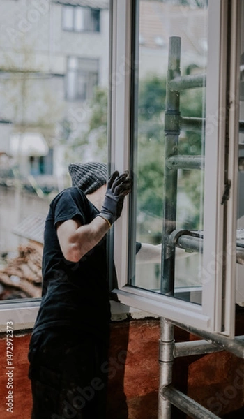 Fototapeta One guy is a builder making repairs by installing a window frame.