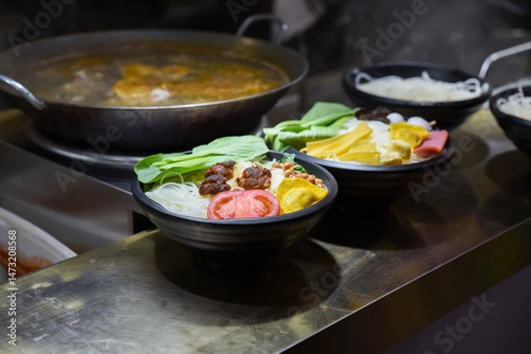 Fototapeta Colorful Luosifen rice noodle bowls with vegetables, tofu, and toppings at a street food stall in Old Street, Yunnan Road, Shanghai, China