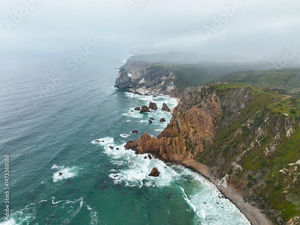 Fototapeta Coastal view of jagged rock cliffs and turquoise ocean in Portugal