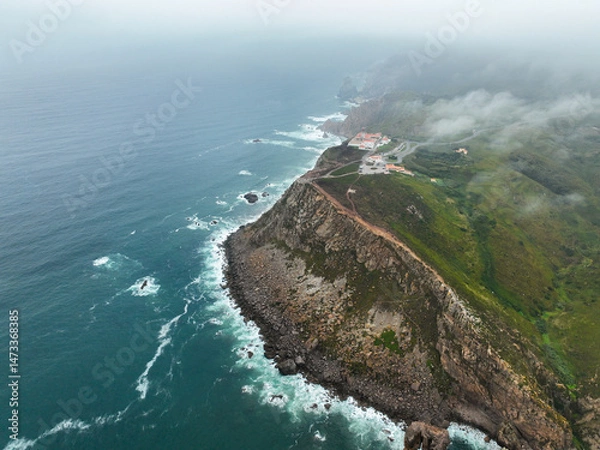 Fototapeta Aerial view of rugged coastline and cliff trails vanishing into ocean mist