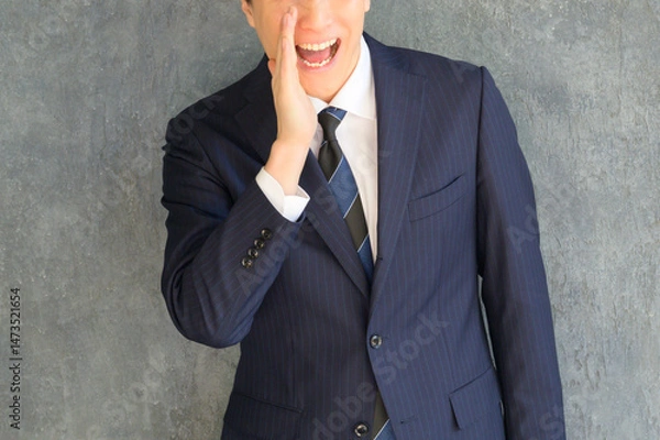 Obraz スーツ姿の男性が片手を口元に添えて笑顔を見せるユーモアあるビジネスポートレート