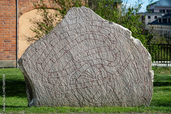 Fototapeta Runestone outside Uppsala Cathedral in Uppsala on a sunny spring day in Sweden. Uppsala was an important site already during Viking ages.