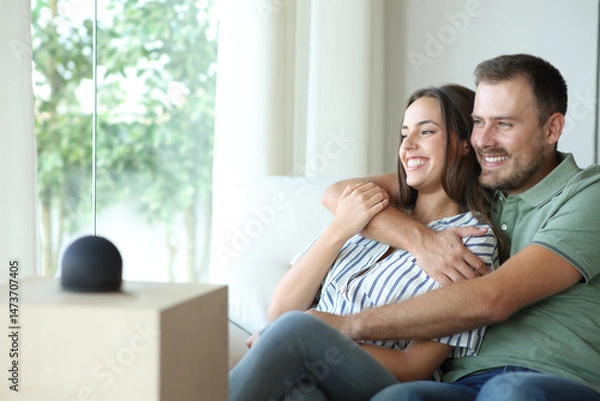 Fototapeta Happy couple with smart speaker enjoying at home