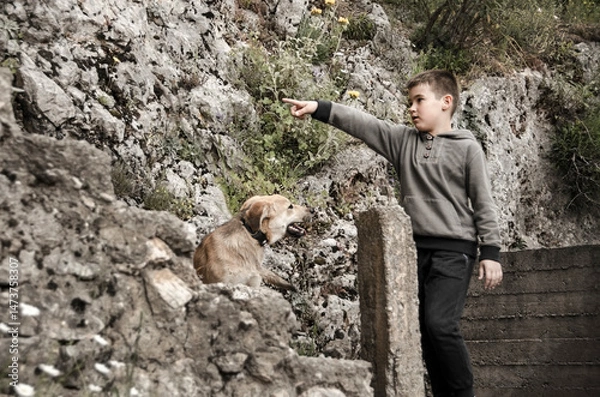 Obraz A boy is training while playing with his dog