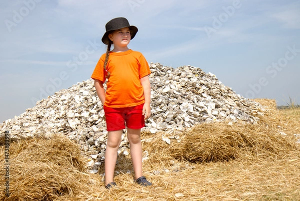 Fototapeta girl standing by oyster shell mountain (conceptual)