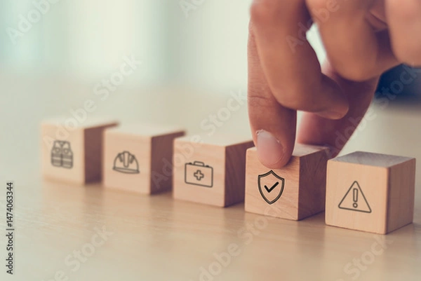 Obraz Work safety and compliance concept. Wooden cube blocks with icon of safety at workplace. Safety first, protections, health, regulations and compliance. Safety in working process. Zero accidents.