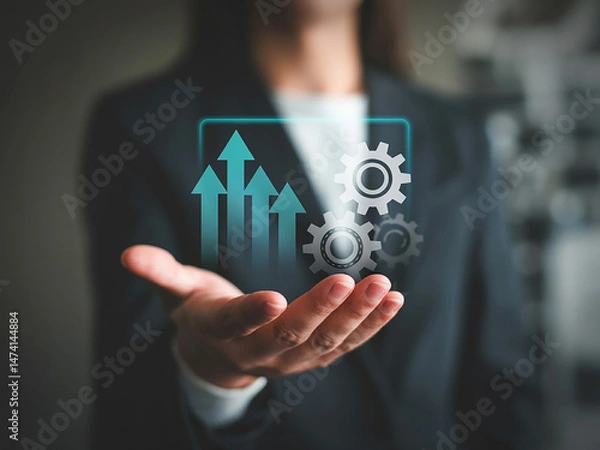 Fototapeta Businesswoman presenting growth arrows and gears on hand for performance and strategy