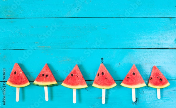 Obraz the summer watermelon slice popsicles on a blue rustic wood background. copy space for designer