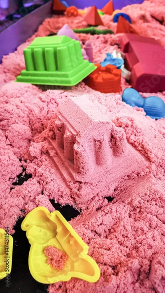 Fototapeta Kinetic sand playtime with colorful molds for endless creative possibilities