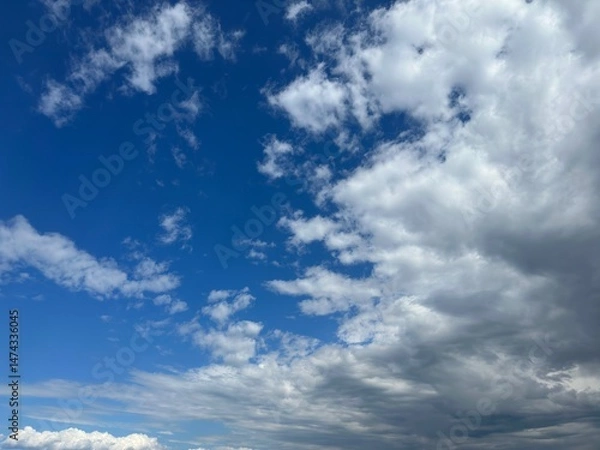 Obraz Blue sky with scattered fluffy white clouds and a touch of gray clouds.