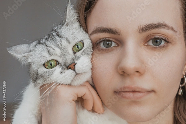 Obraz face and muzzle close up of human and cat. pet and human faces. biology concept