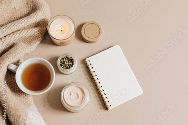 Obraz Flat lay scene with cozy diary, herbal tea cup, burning candle, organic balm in eco-friendly jar, and soft blanket, top view with emotional skincare feeling and empty area for text