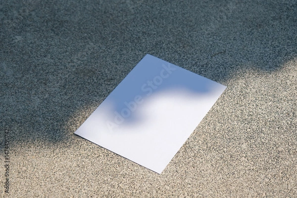 Fototapeta empty vertical paper poster mockup on concrete stone floor or pavement outdoors, shadow overlay
