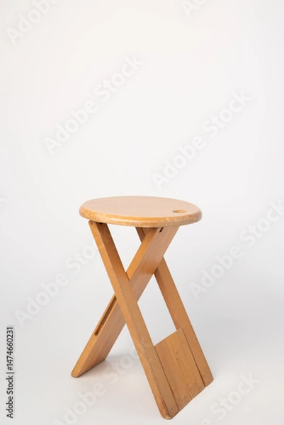 Fototapeta Small, folding, used wooden stool that can also serve as a side table,.