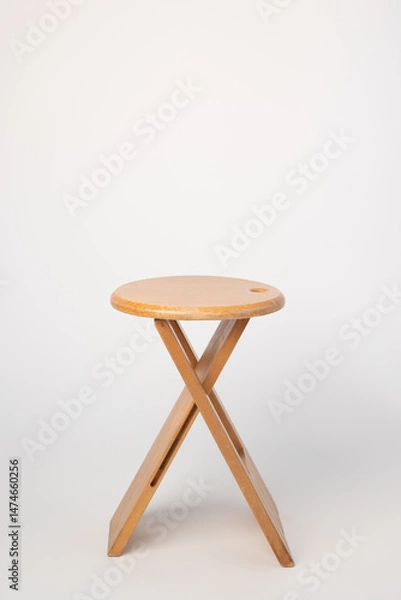Fototapeta Small, folding, used wooden stool that can also serve as a side table,.