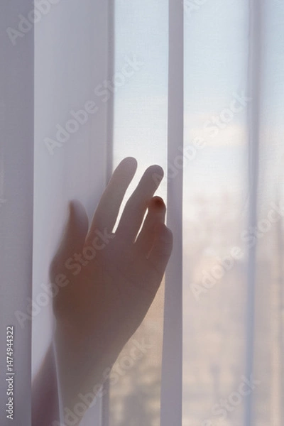 Obraz A woman's hand is visible through a nylon curtain