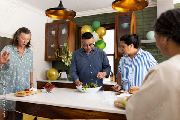 Obraz Preparing healthy salad, seniors in modern kitchen having conversation together