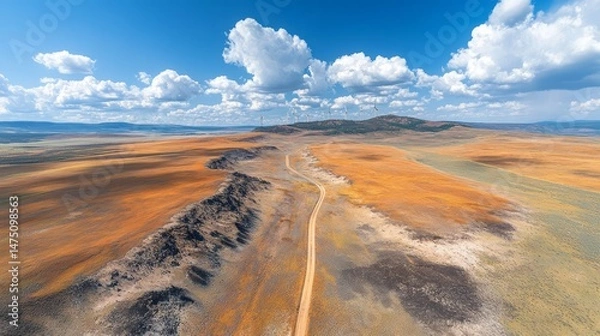 Fototapeta High-altitude panorama of a scenic, dusty road through a colorful landscape.