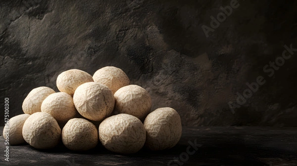 Fototapeta A pile of whole Makhana nuts arranged on a dark surface, beige with light ridges, showcasing their natural texture and color for a wholesome, healthy snack look.