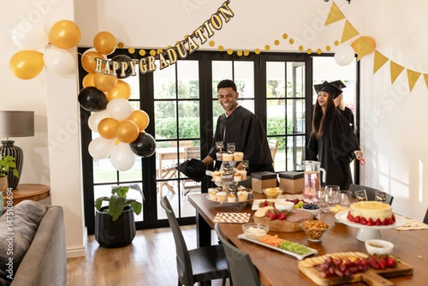 Obraz Graduates celebrating at home with food and decorations, smiling and enjoying moment