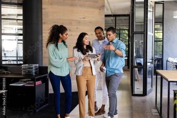 Obraz Diverse business team discussing project while walking through modern office hallway
