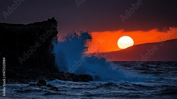 Obraz The ocean waves crash against a dark rocky cliff at sunset