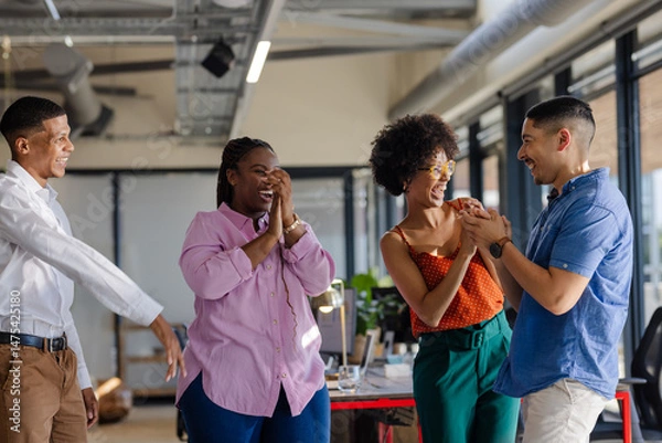 Fototapeta In office, diverse colleagues celebrating success, sharing joyful moments together