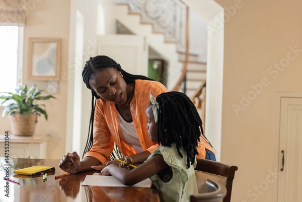 Obraz Mother helping daughter with homework at home, fostering learning and support