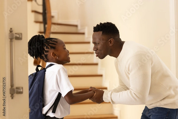 Obraz Father encouraging daughter with backpack before school on staircase at home