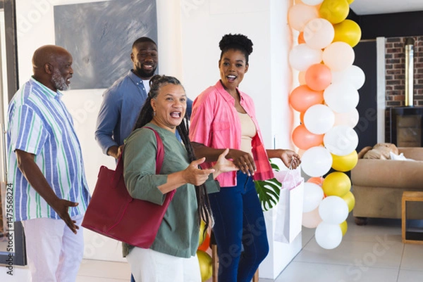Obraz Arriving at home, family celebrating with colorful balloons and smiling together