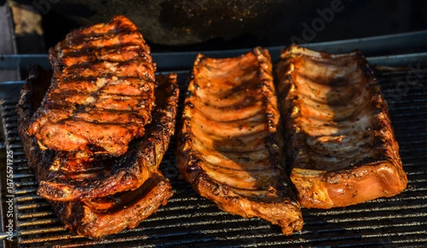 Fototapeta 
Grilled pork ribs prepared on a barbecue grill with visible grill marks. Perfectly browned and seasoned meat ready for serving in an outdoor cookout setting