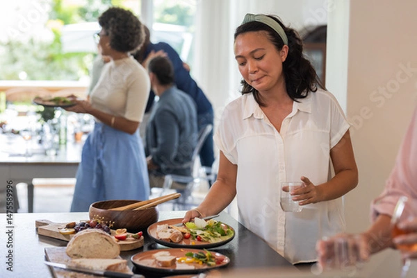 Fototapeta Guests enjoying buffet lunch with fresh salads and bread at wedding reception