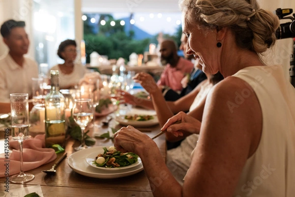 Obraz At wedding reception, guests sharing laughter and conversation during elegant dinner