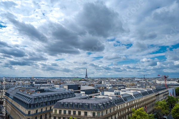 Fototapeta Panoramic View of Paris Rooftops with Eiffel Tower Under Dramatic Cloudy Sky