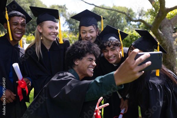 Obraz Graduating students taking selfie outdoors, celebrating with joy and excitement