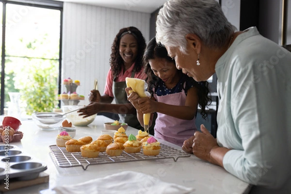 Fototapeta Baking cupcakes, three generations decorating with icing, sharing joyful family moments