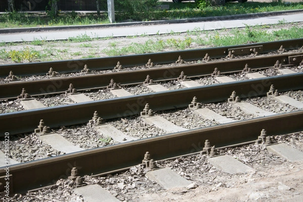 Fototapeta close-up of tram rails and concrete sleepers covered with crushed stone