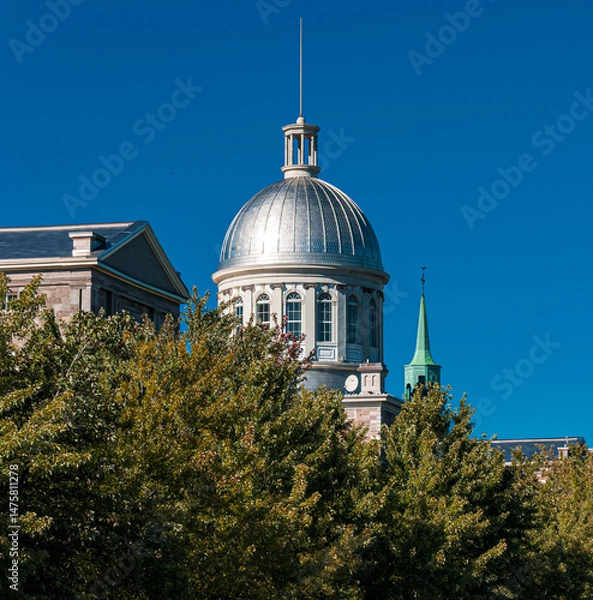 Obraz The iconic silver dome of Bonsecours Market rises above the trees in Old Montreal, Quebec. Captured on a clear blue sky day, this landmark reflects classic architecture and history.