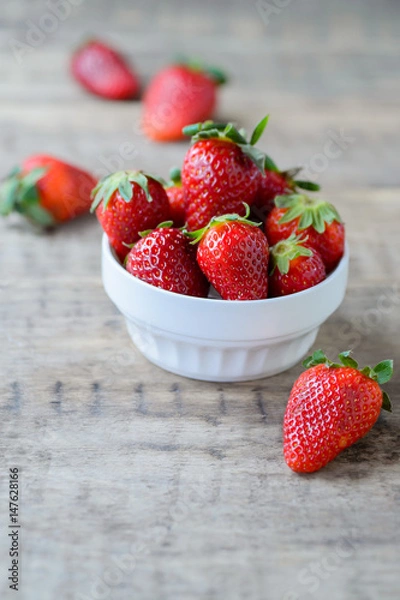 Obraz Ripe red fresh strawberry on a rustic wooden table in white bowl