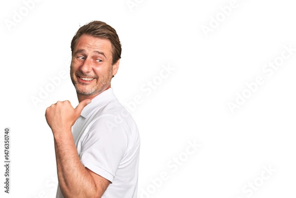 Fototapeta A middle-aged man isolated points with thumb finger away, laughing and carefree.