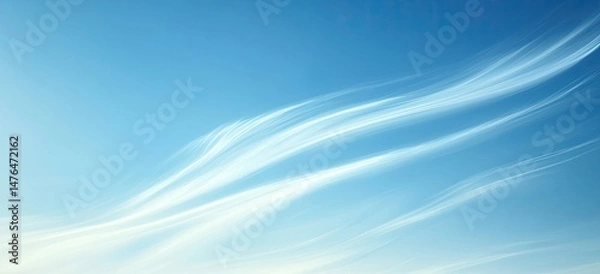 Fototapeta Wispy clouds flowing across a vibrant blue sky