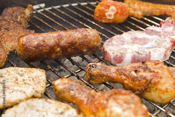 Obraz Sausages, beef and other meat on a barbecue