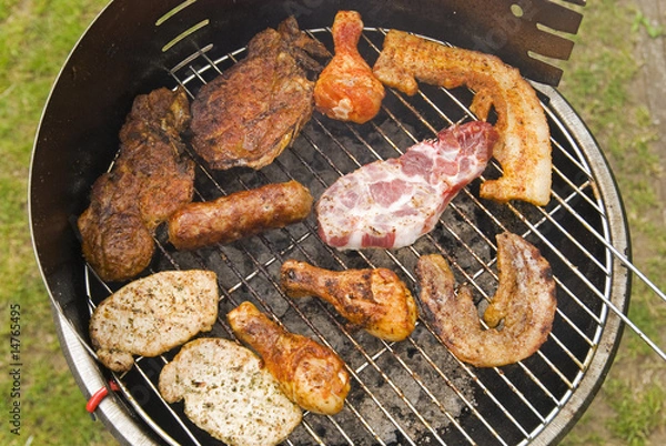 Obraz Sausages, beef and other meat on a barbecue