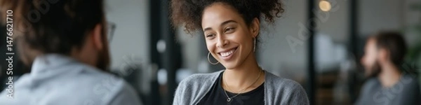 Obraz Smiling african female adult engaging in a conversation in office setting
