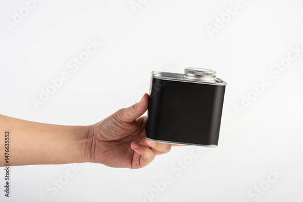Fototapeta Black can for packaging in hand on white background.