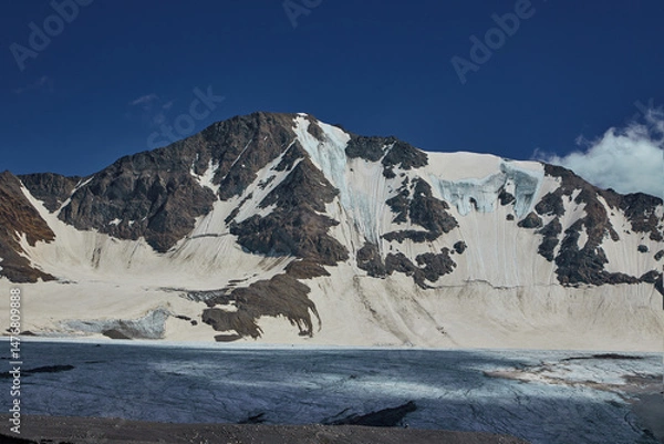 Obraz Snow-capped peaks rise dramatically above glacial formations, reflecting sunlight on a serene ice surface, creating a breathtaking view of natures untouched beauty in a remote area.Caucasus